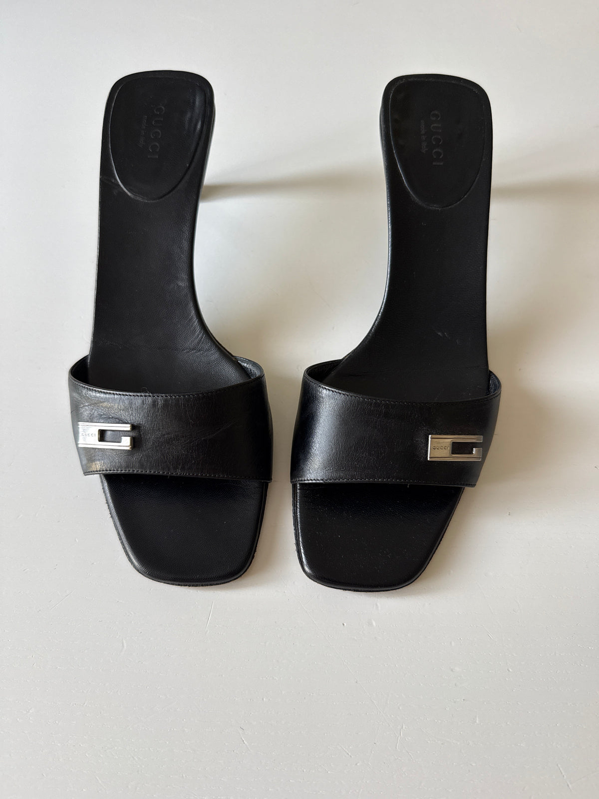 Mules Gucci nere con dettaglio G in metallo