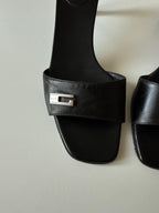 Mules Gucci nere con dettaglio G in metallo
