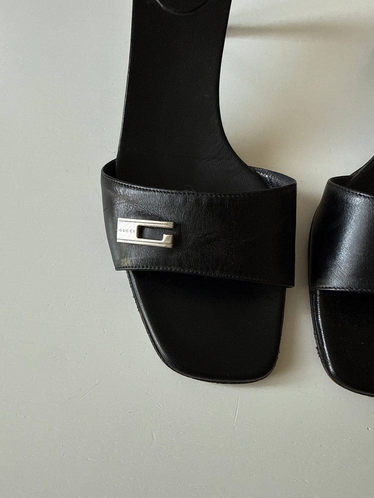 Mules Gucci nere con dettaglio G in metallo