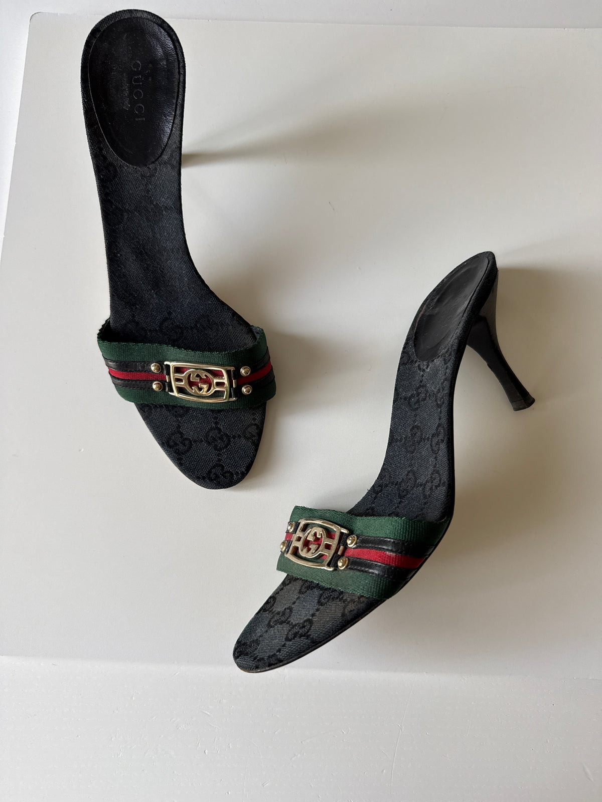 Mules Gucci GG Canvas nere con nastro Web e logo GG dorato