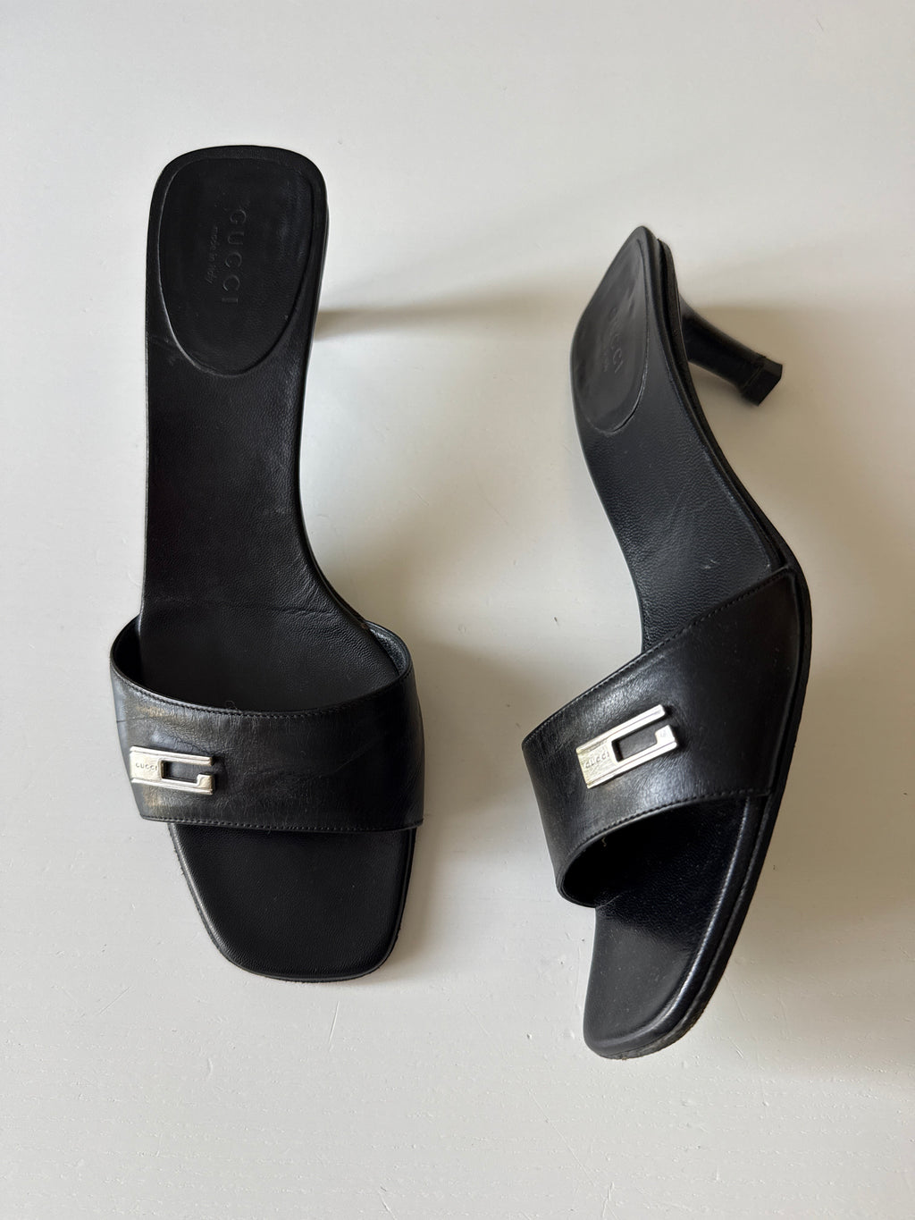 Mules Gucci nere con dettaglio G in metallo