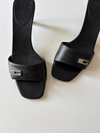 Mules Gucci nere con dettaglio G in metallo
