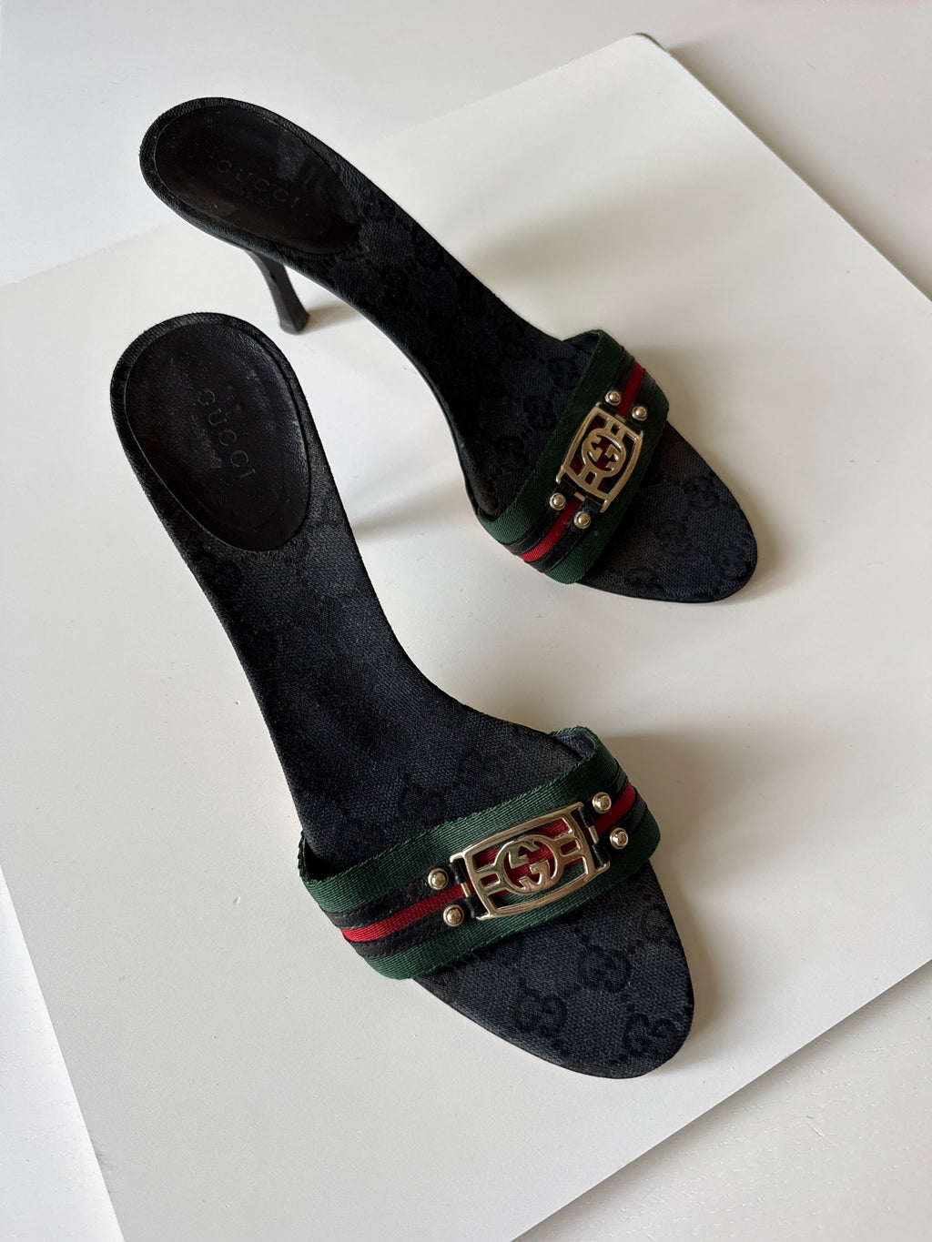 Mules Gucci GG Canvas nere con nastro Web e logo GG dorato